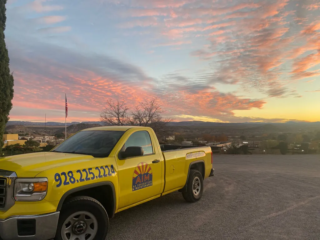 A yellow pic-up truck with company logo